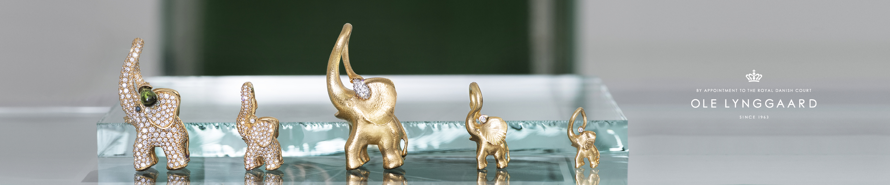 The Ole-Lynggaard-Copenhagen logo with a collection of 5 different elephants.
